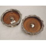 A pair of Georgian silver bottle coasters having gadrooned and scroll decoration to rims and