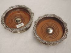 A pair of Georgian silver bottle coasters having gadrooned and scroll decoration to rims and