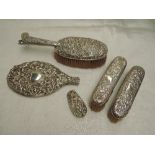 A selection of HM silver dressing table items including brushes with repousse cherubic decoration