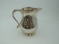 A silver cream jug of plain baluster form having thumb rest handle, London 1978, Edward Barnard &