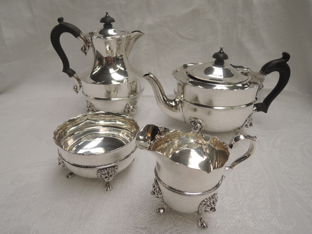 A 1920's silver four piece tea set of plain form having reided waists, lion mask paw feet and shaped