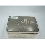 A Chinese silver box having black laquered wood lining, floral engravings to sides and yellow/rose