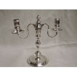 A silver candelabra having central shaped column to three candle holders, two having wax saucers,