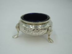 A small Victorian silver salt cellar of cauldron form having trefoil hoof feet, moulded floral