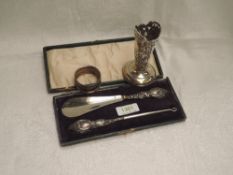 A small selection of HM silver including a cased silver handled button hook and shoe horn, napkin