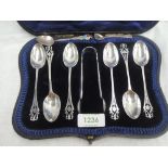 A cased set of six Edwardian silver tea spoons with matching sugar nips having pierced decoration to