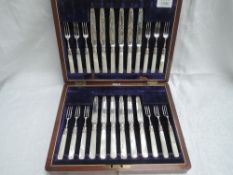 An Edwardian canteen of silver fruit knives and forks (12 setting) having silver blades and mother