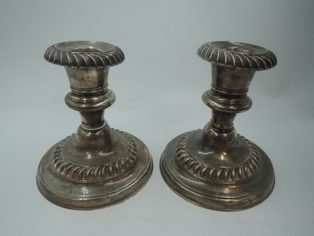 A pair of Edwardian silver candle sticks of squat form having gadrooned decoration, removable - Image 2 of 3