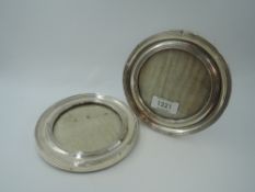 A pair of silver photograph frames of circular form having wooden easel reverse (one stand missing),