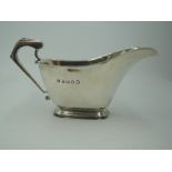 A silver Art Deco style sauce boat of plain form having architectural handle and rectangular foot,
