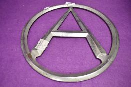 A circular framed letter A in cast metal from an Atkinsons truck