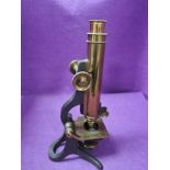 An early 20th century scientific microscope having a brass and cast body with mahogany case made