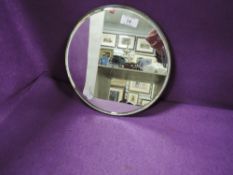 A circular dress or hall way mirror having bevel edged glass and metal frame