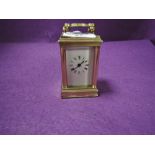 A miniature French brass cased carriage clock having visible escape and bevel edged panels stamped