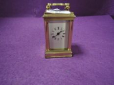 A miniature French brass cased carriage clock having visible escape and bevel edged panels stamped