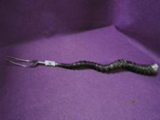 An antique toasting fork having African animal horn handle grip