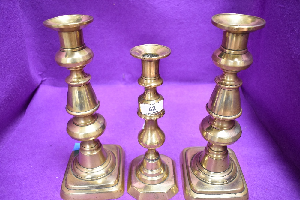 A pair of large Victorian cast brass candle sticks and similar