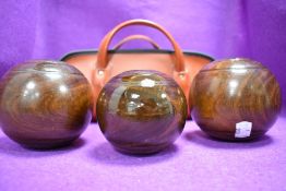 A set of three antique crown green bowls possibly lignum wood in case