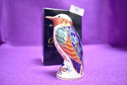 A ceramic Royal Crown Derby paper weight or figure of a Humming Bird having gold stopper and box