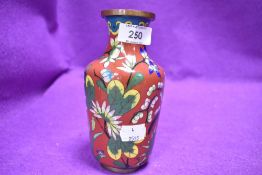 A cloisonne vase having red ground with decorated flowers