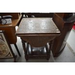 A late Victorian carved table having four drop leaves, turned legs and spindle gallery to lower
