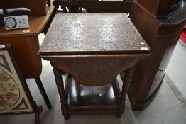 A late Victorian carved table having four drop leaves, turned legs and spindle gallery to lower