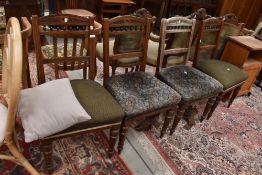 A set of four 19th Century oak railback dining chairs having overstuffed seats and turned legs,