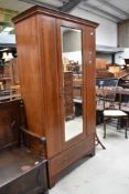 An Edwardian mahogany mirror door wardrobe having typical inlaid decoration