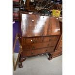 An early 20th Century mahogany bureau on heavy shaped legs with ball and claw feet