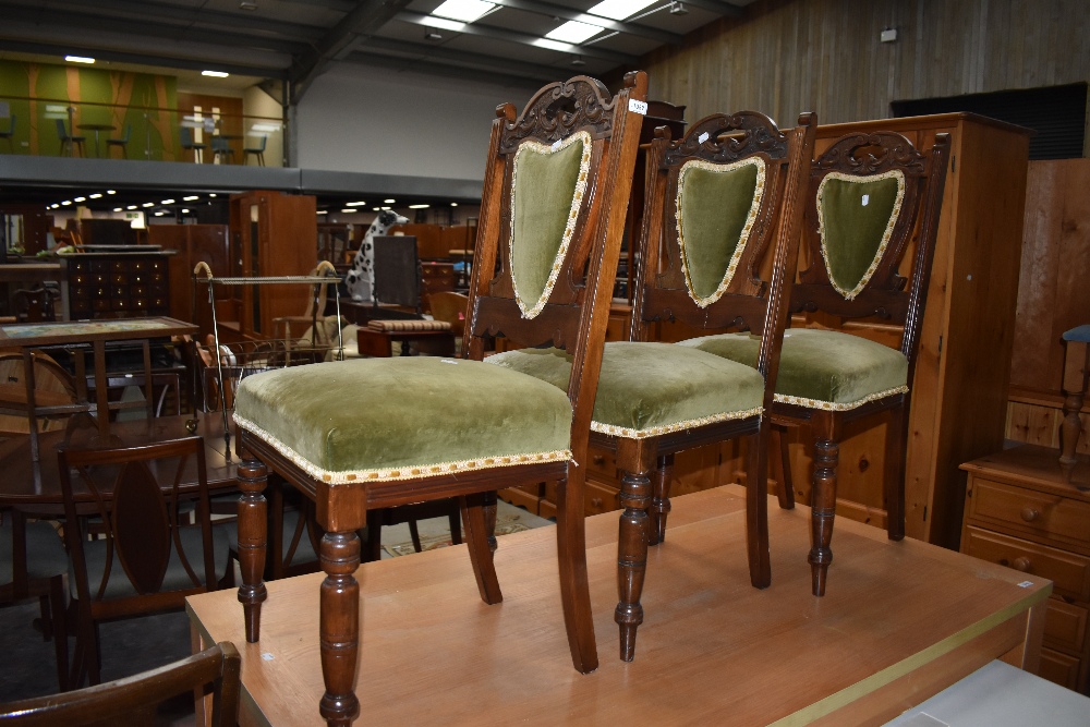 A set of three late Victorian carved frame dining chairs with green satin upholstery