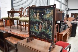 An early 20th Century firescreen having oriental fabric panel