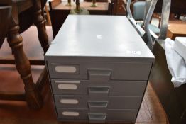 A set of gun metal filing drawers, some stationery contents