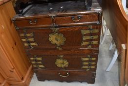 An Oriental style oak and brass cabinet