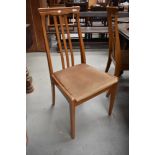 A set of four modern beech wood kitchen chairs with rail back