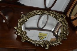 A reproduction gilt plaster frame mirror, scroll frame