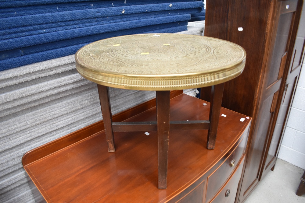 A traditonal Indian brass top coffee table on plain wood frame, diameter approx. 60cm