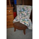 A vintage low seat nursing chair having original upholstery and later loose cover