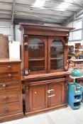 A Victorian mahogany bookcase having glazed top over frieze drawer and cupboard base