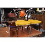 A pair of Victorian mahogany dining chairs havkng overstuffed seats