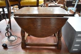 A reproduction oak occasional drop leaf table of traditional form