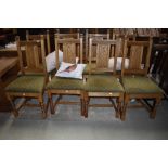 A set of eight Old Charm or similar dining chairs in golden oak, having Gothic style carving to