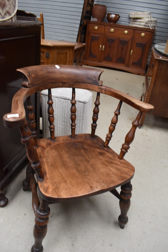 A late 19th or early 20th Century smokers bow style spindle back armchair