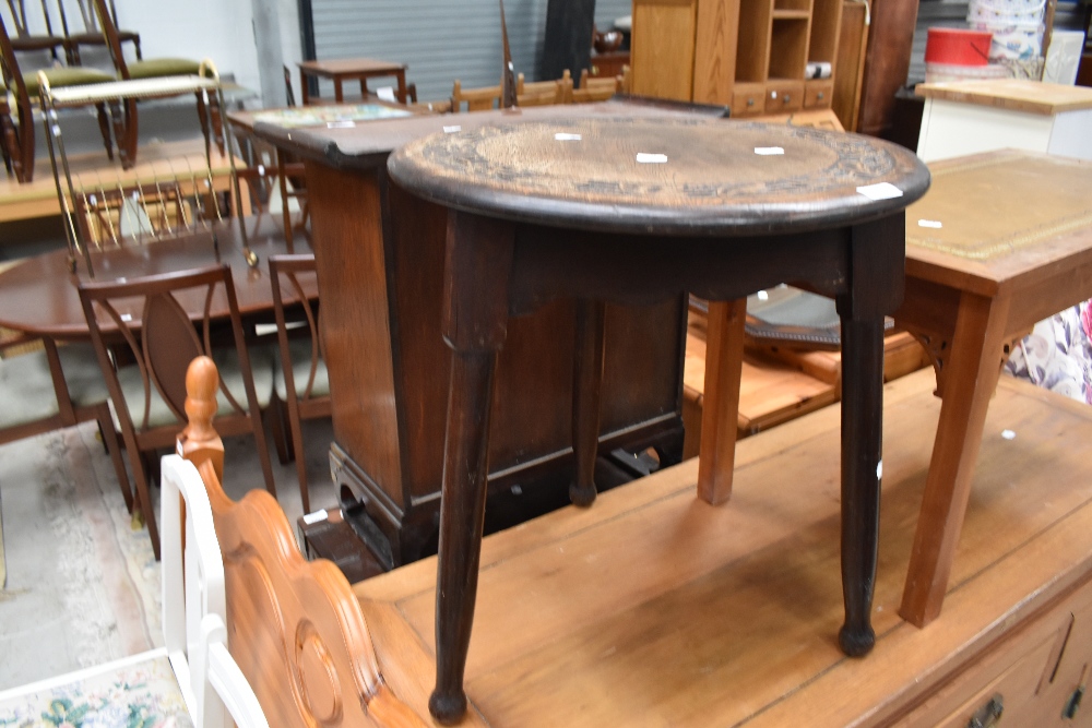 A small occasional table on cricket style frame having carved top , diameter approx. 48cm