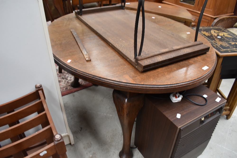 An oval oak dining table late Victorian having large carved legs and additional extendable leaf