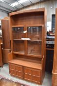 A mid century teak display cupboard having glazed top and cupboard base by Nathan