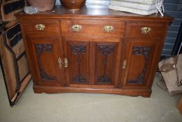 A late Victorian mahogany sideboard having Art Nouveau styling to panelled doors and stylised