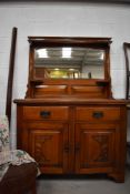 An Art Nouveau oak dresser side board having original handles and mirror back