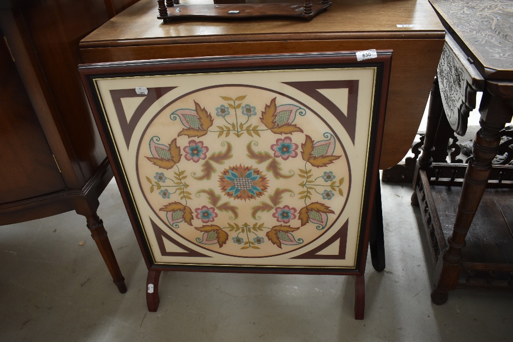 A reproduction embroidered fire screen