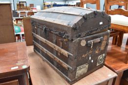 A large domed top travel trunk, bearing shipping labels including Union Castle line