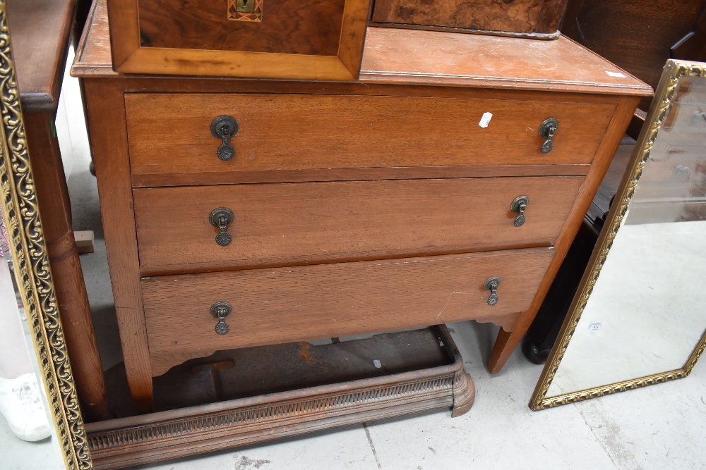 An early 20th century oak chest of three drawers on tapered legs